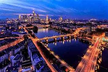 Aerial view of a city skyline at night, illuminated by buildings and streetlights